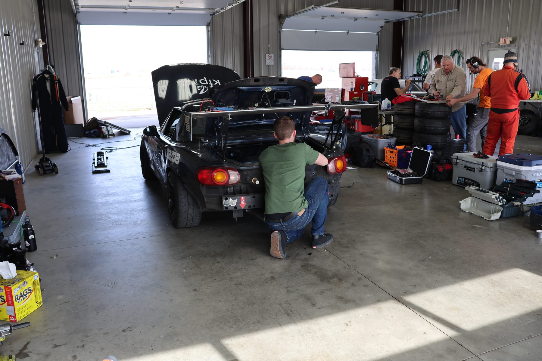 The Senhauser Racing crew working on the #302 Mazda Miata in the garage